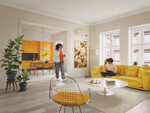 Mutter und Kind in einem modernen Wohnzimmer mit einer Samsung Klimaanlage an der Wand. Die Mutter trinkt Kaffee, während das Kind vor einem Tablet sitzt, umgeben von gelben Möbeln und Pflanzen. | © Samsung
