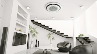 Moderne Wohnung mit einem Samsung 360-Grad-Klimagerät an der Decke. Der Raum ist lichtdurchflutet, mit minimalistischer Einrichtung und einer eleganten Treppe. | © Samsung